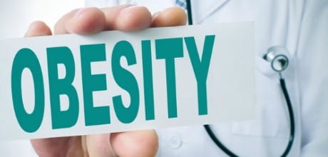 A doctor holding a sign saying obesity